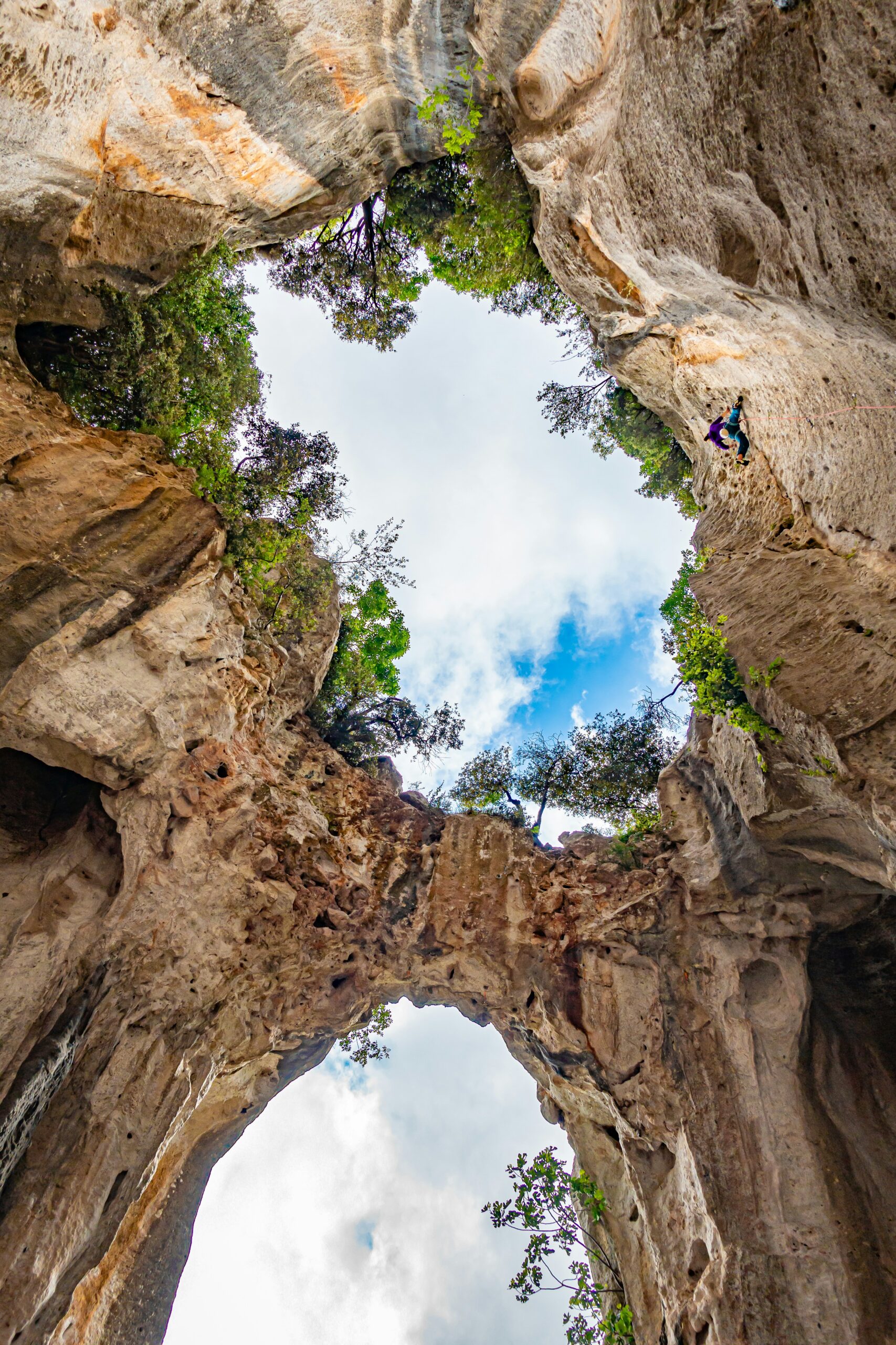 Eine Fischaugen-Panoramaaufnahme einer Kletterin in Finale Ligure, Savone, Italien, in der Grotta dell'Edera