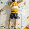 Mensch beim Klettern im Vorstieg in einer Kletterhalle beim Clippen
