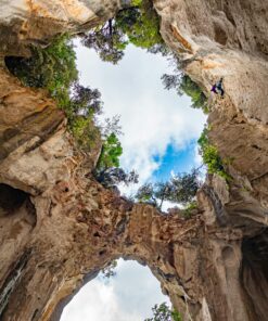 Eine Fischaugen-Panoramaaufnahme einer Kletterin in Finale Ligure, Savone, Italien, in der Grotta dell'Edera